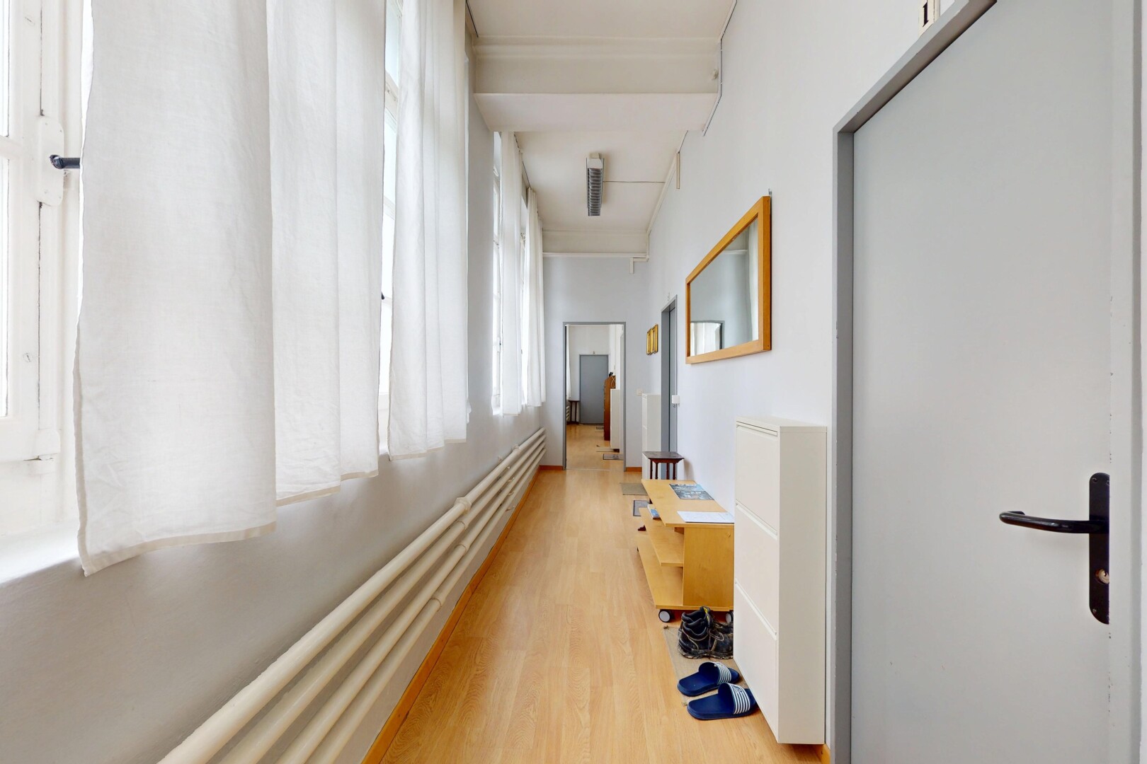 couloir avec sol en finition bois, wood finish floor, inside property, lumière naturelle, et natural light