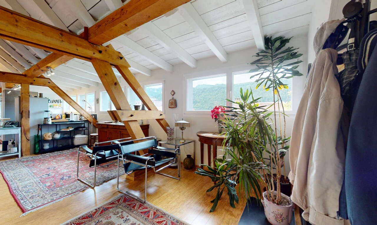salon avec wood finish floor, sol en finition bois, beamed ceiling, plafond à poutres, et natural light
