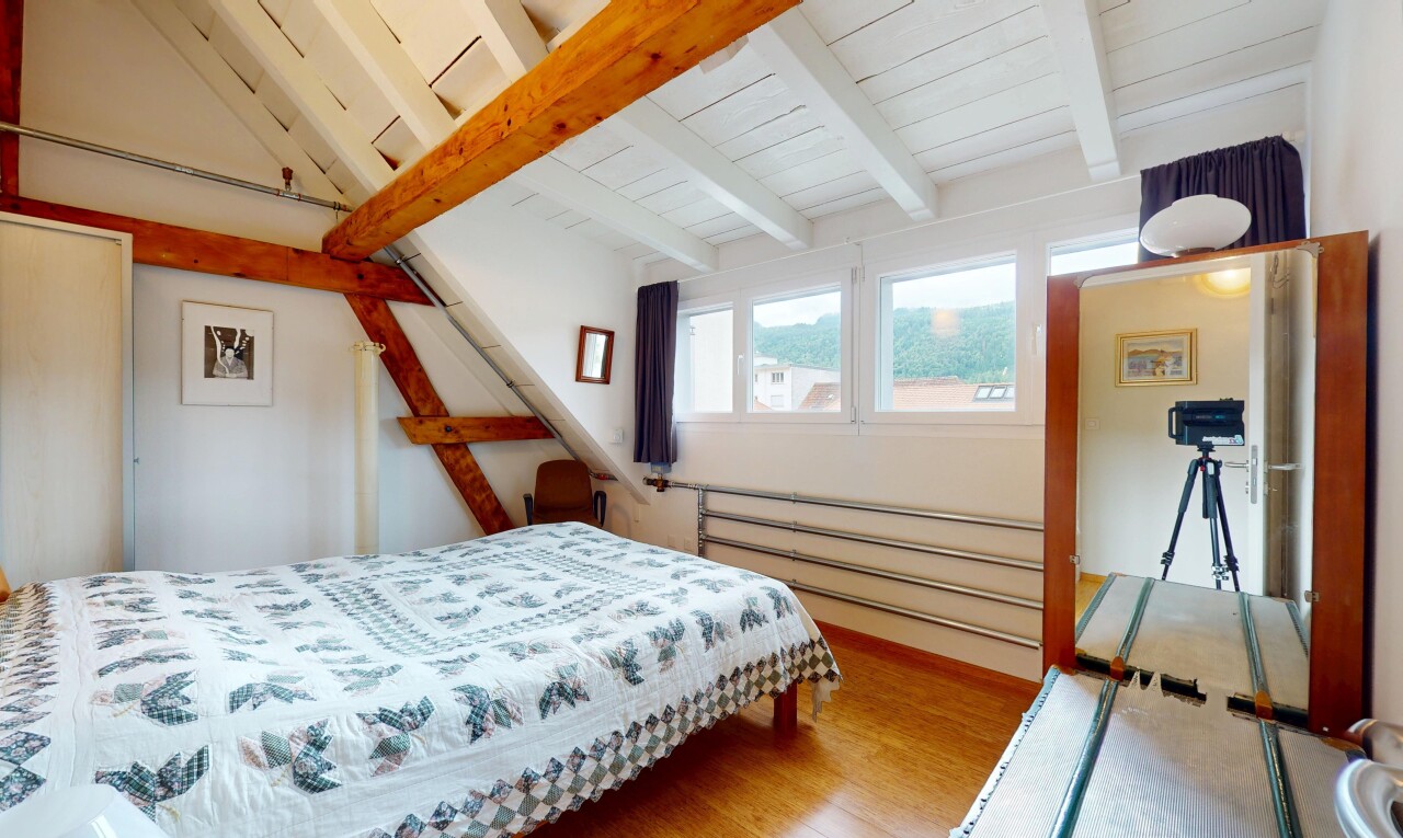 chambre avec wood finish floor, sol en finition bois, beamed ceiling, plafond à poutres, et inside property