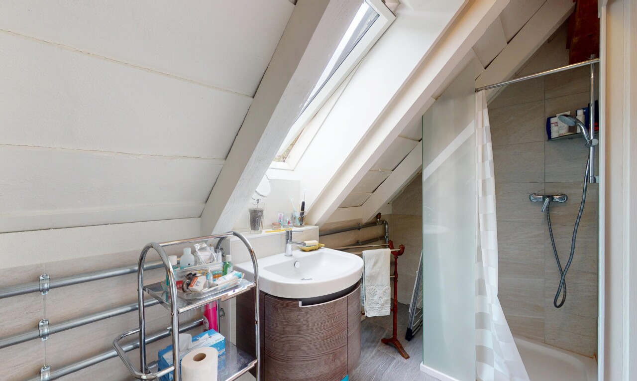 salle de bains avec puits de lumière, salle de bain complète, lavabo (ou coiffeuse selon le contexte), douche, et inside property
