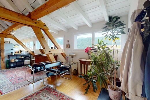 salon avec wood finish floor, sol en finition bois, beamed ceiling, plafond à poutres, et natural light