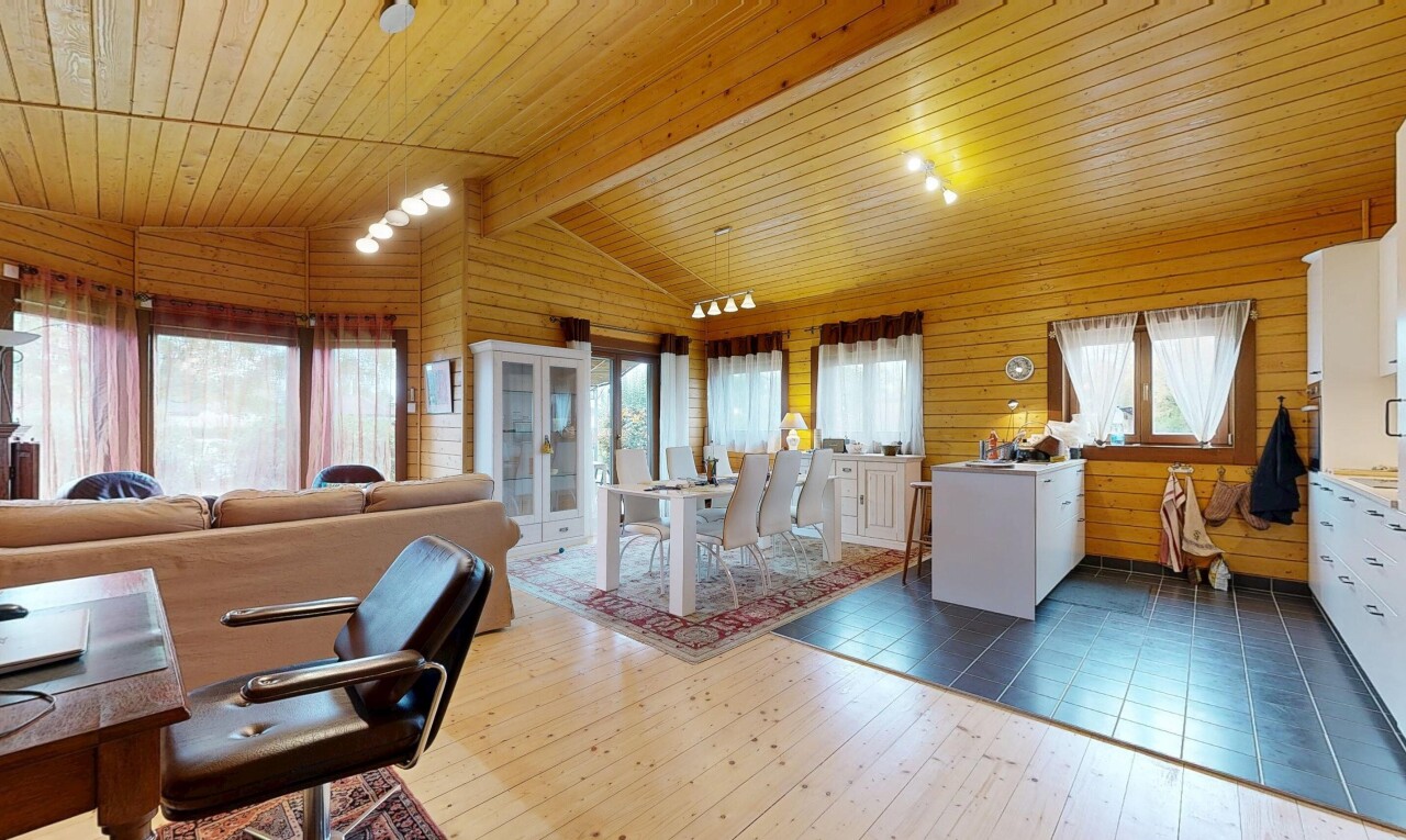 wohn- / esszimmer mit holzfußboden, wood finish floor, dachschräge, natürliches licht, und vaulted ceiling