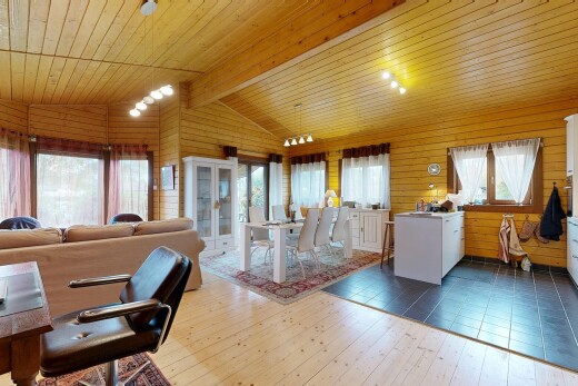 wohn- / esszimmer mit holzfußboden, wood finish floor, dachschräge, natürliches licht, und vaulted ceiling