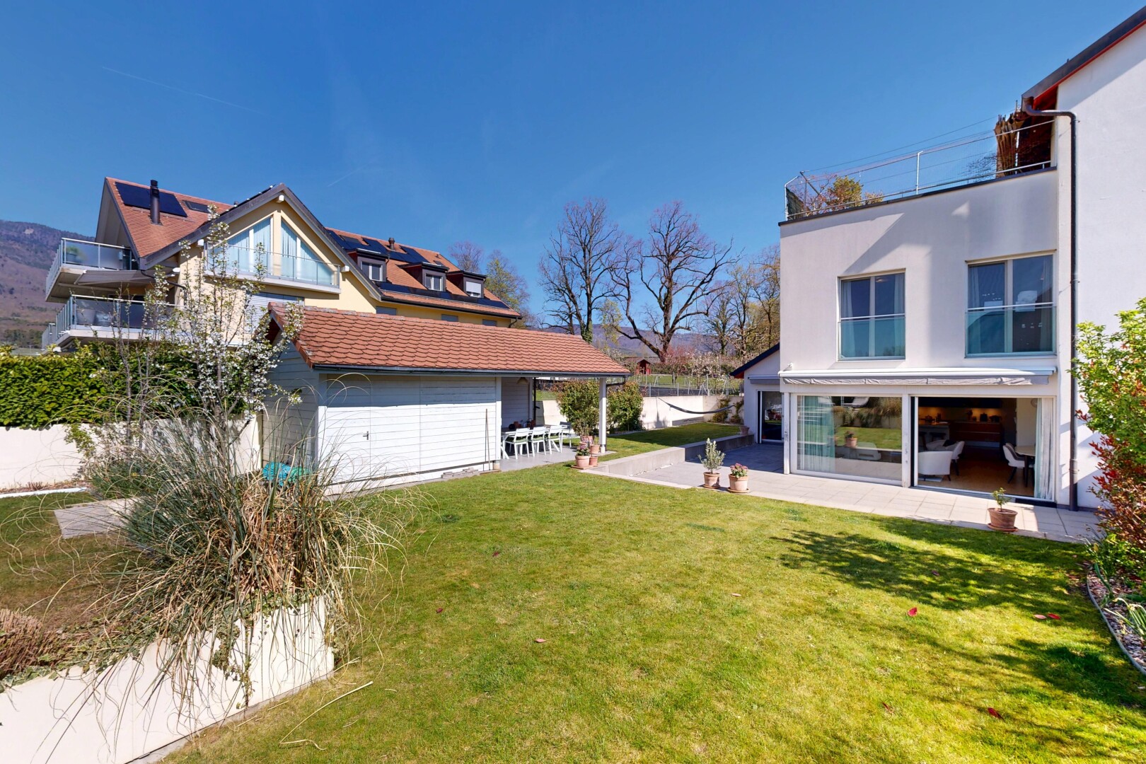 façade avec bardage en stuc, terrasse, pelouse, day time, et property visible