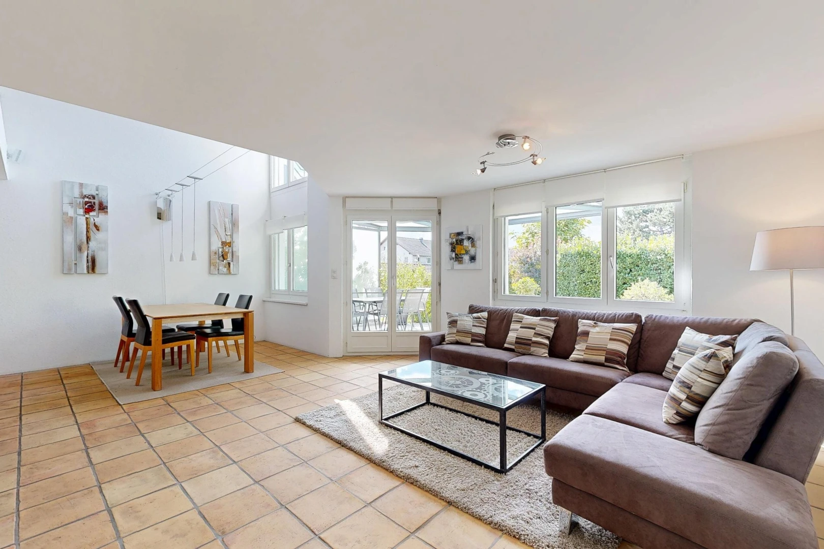living / dining room with rail lighting, access to exterior, and light tile patterned floors