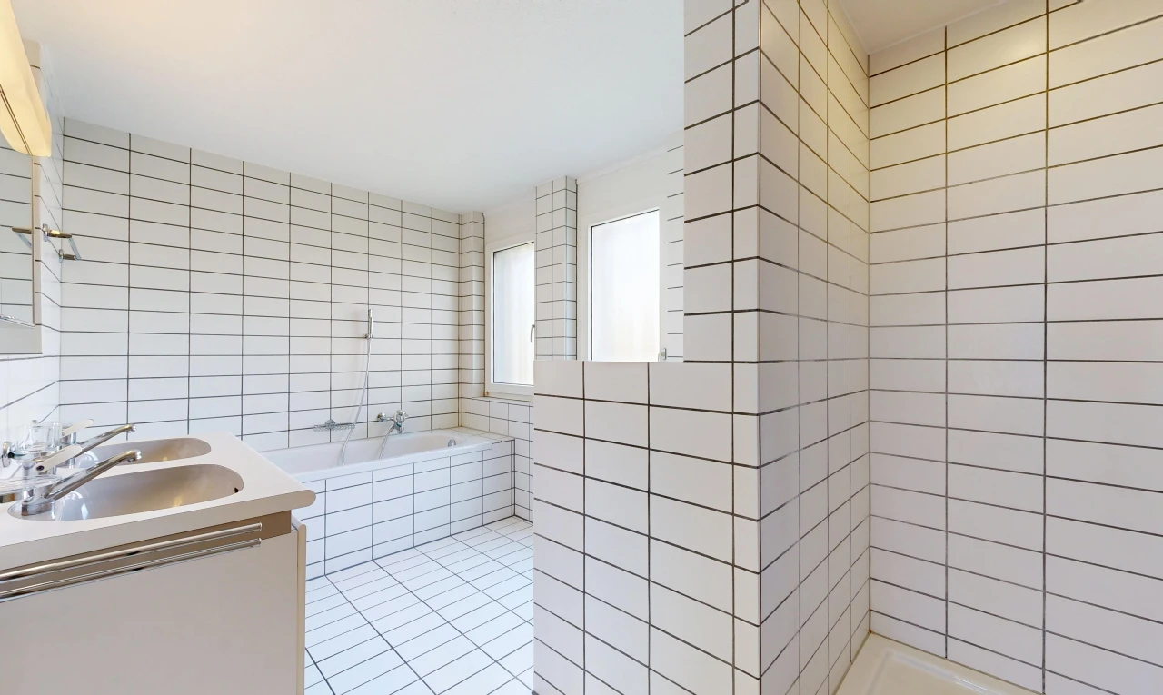 bathroom with tile walls, double vanity, a bath, a tile shower, and light tile patterned floors