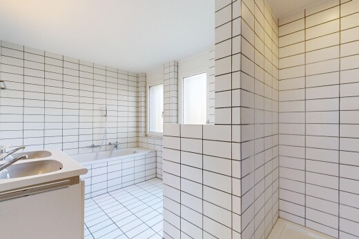 bathroom with tile walls, double vanity, a bath, a tile shower, and light tile patterned floors