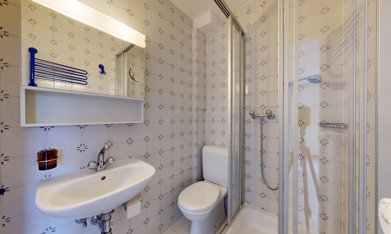 salle de bains avec douche, évier, salle de bain complète, toilette, et inside property