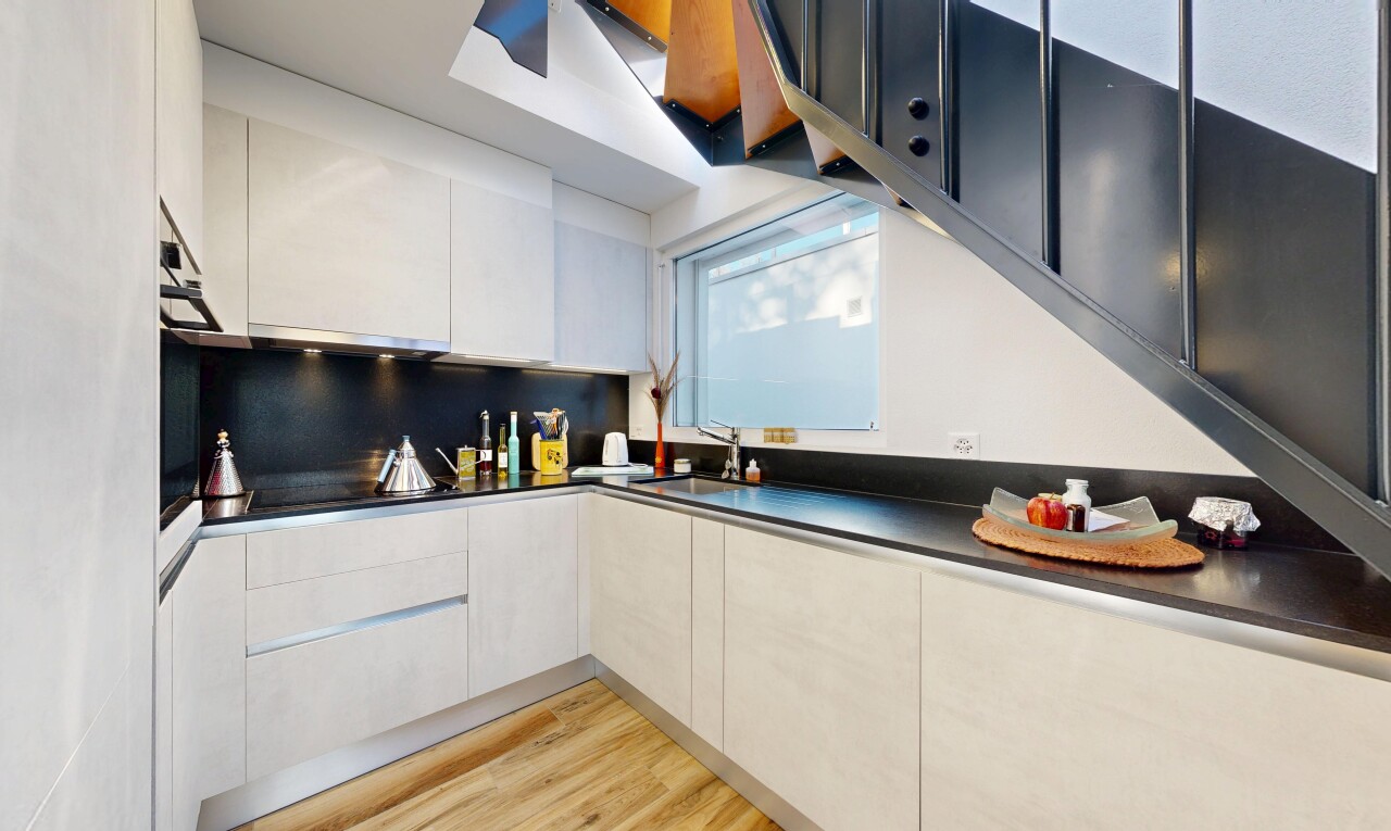 cuisine avec wood finish floor, sol en finition bois, plans de travail, inside property, et armoires à panneau plat