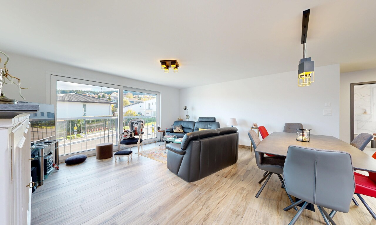 salon / salle à manger avec télévision, lumière naturelle, natural light, sol en finition bois, et wood finish floor