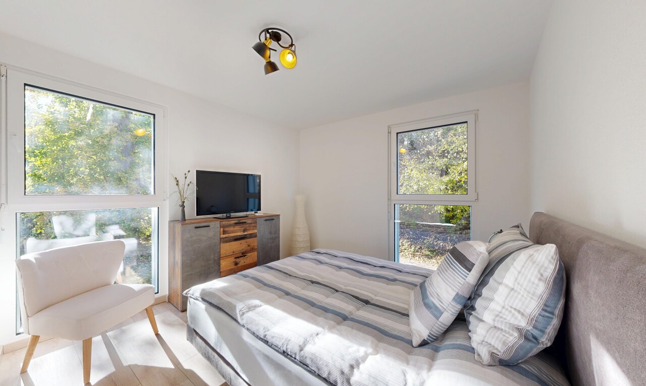 chambre avec inside property, télévision, drywall, cloison sèche, et natural light