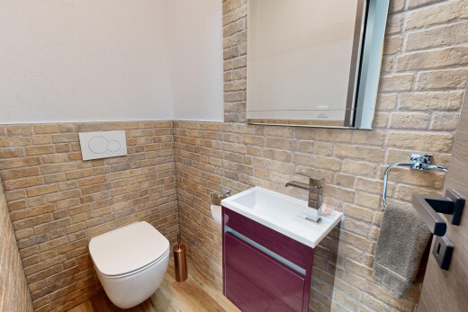 half bath featuring vanity, tile walls, and a wainscoted wall