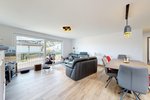 salon / salle à manger avec télévision, lumière naturelle, natural light, sol en finition bois, et wood finish floor