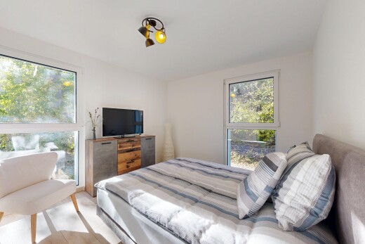 chambre avec inside property, télévision, drywall, cloison sèche, et natural light