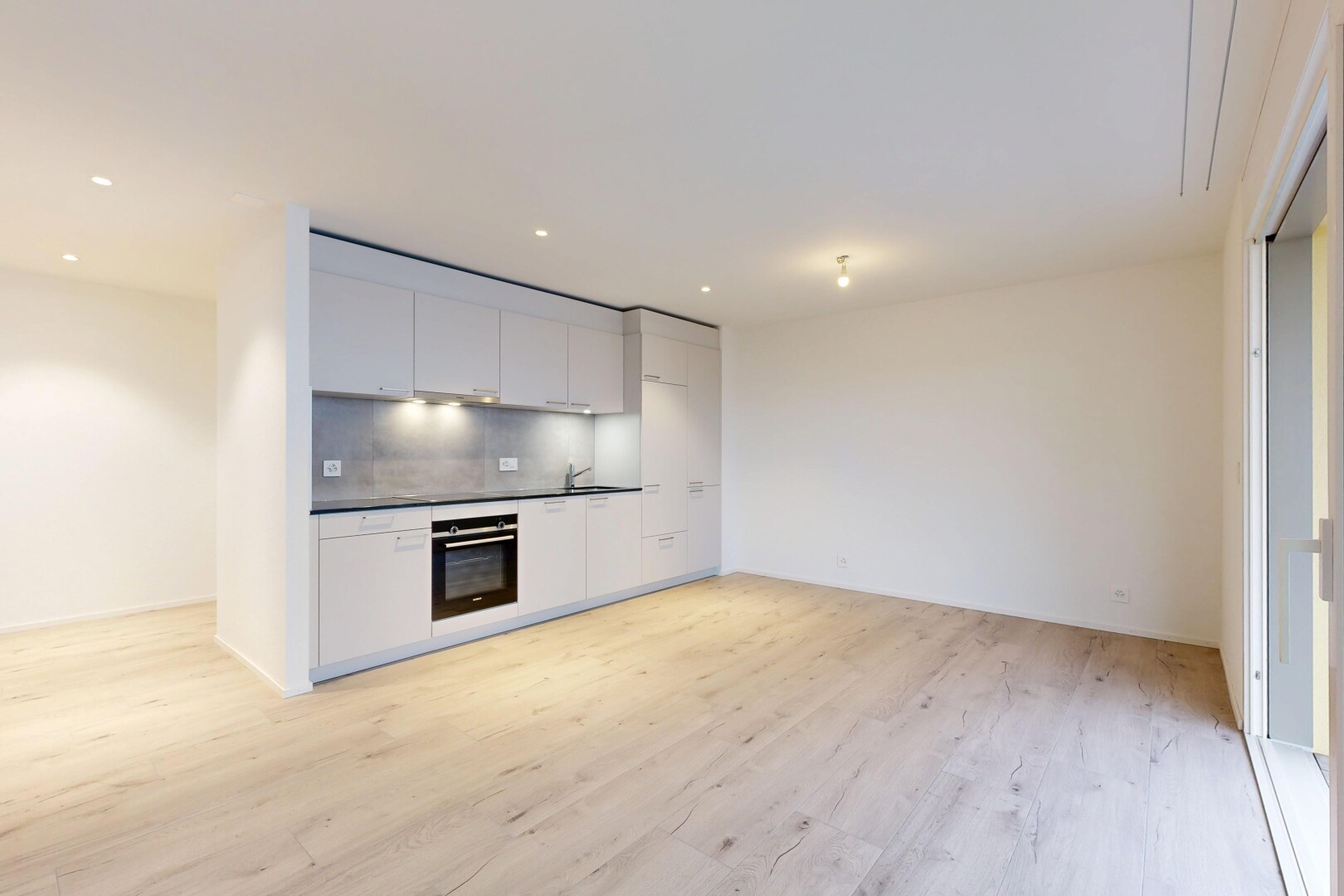 cuisine avec plans de travail, armoires blanches, sol en finition bois, wood finish floor, et cloison sèche
