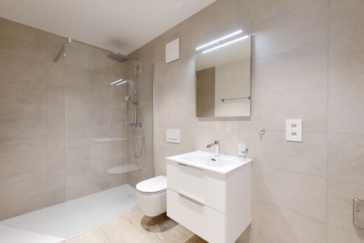 salle de bains avec miroir, lavabo (ou coiffeuse selon le contexte), salle de bain complète, douche, et mur en carrelage