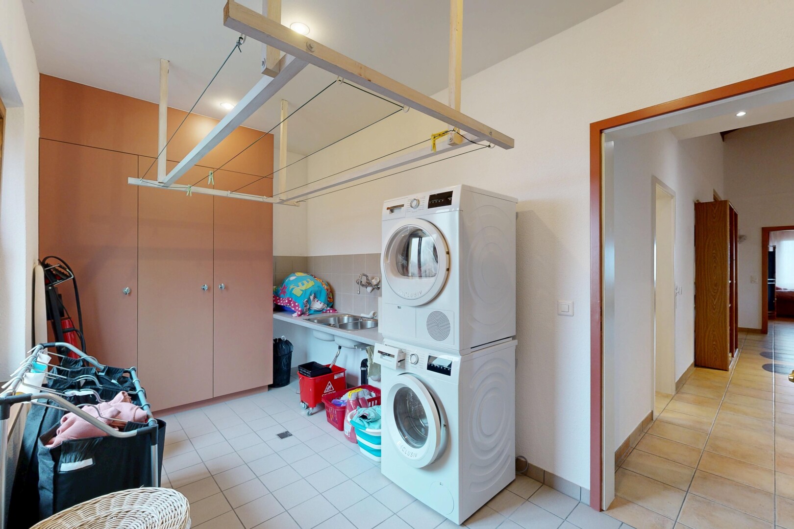 buanderie avec buanderie, cloison sèche, drywall, sol en carrelage, et tile floor