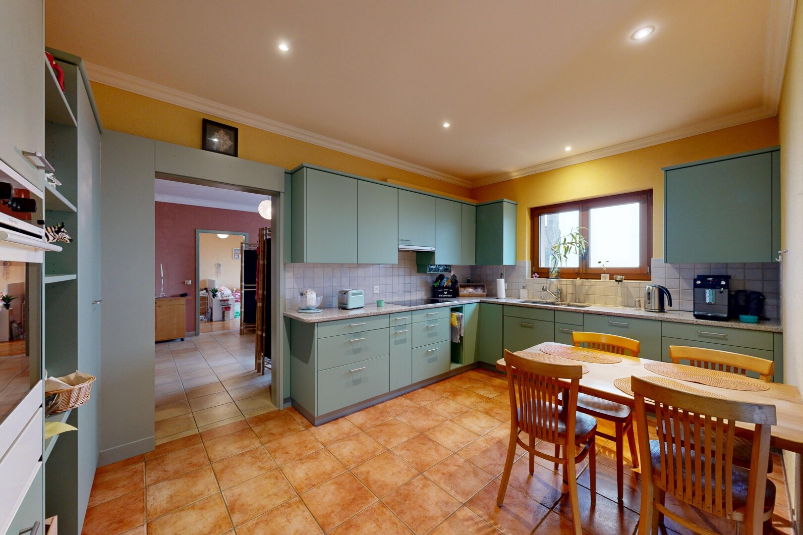 cuisine avec armoires vertes, moulures, crown molding, inside property, et natural light