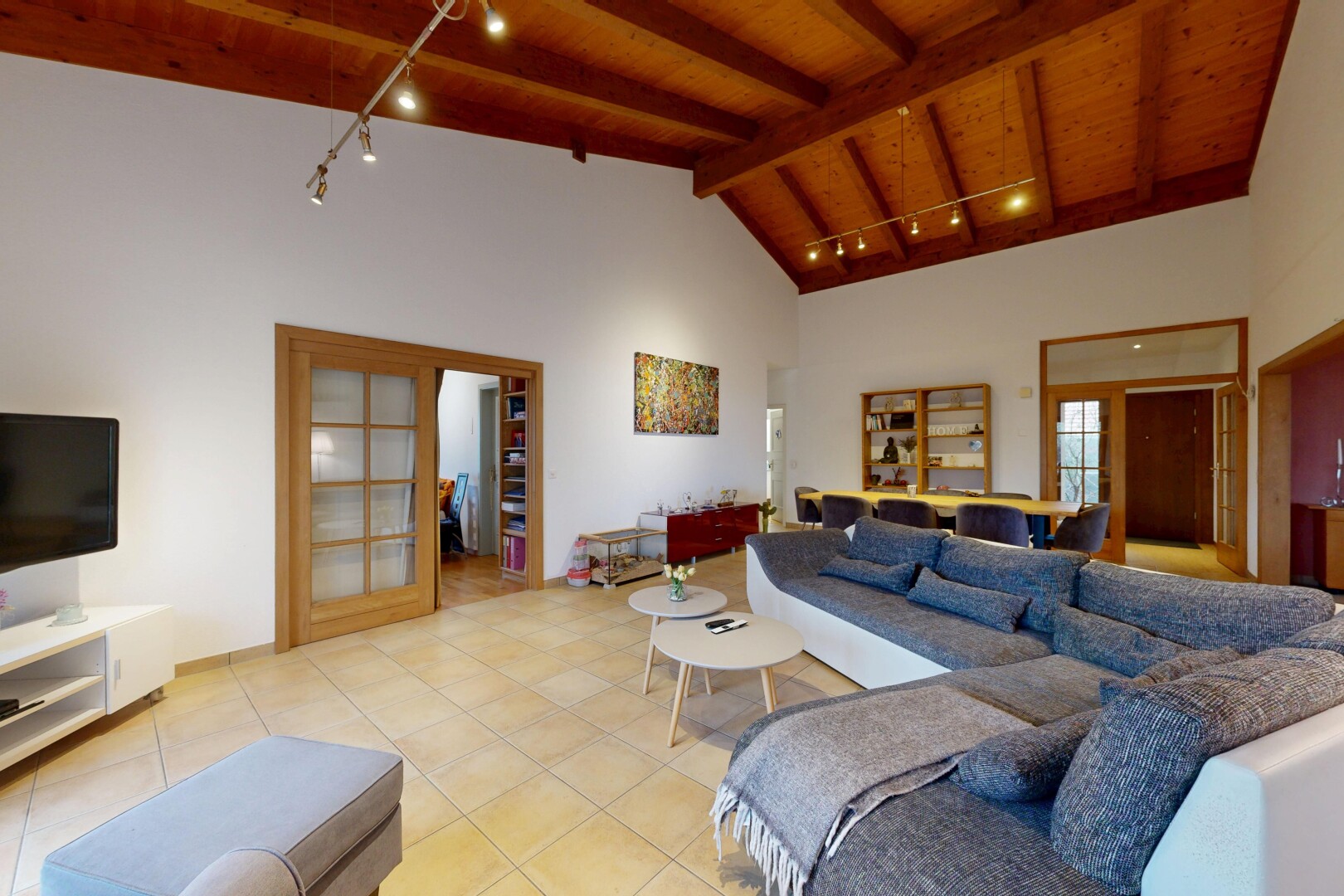salon avec éclairage sur rail, track lighting, inside property, télévision, et plafond en bois