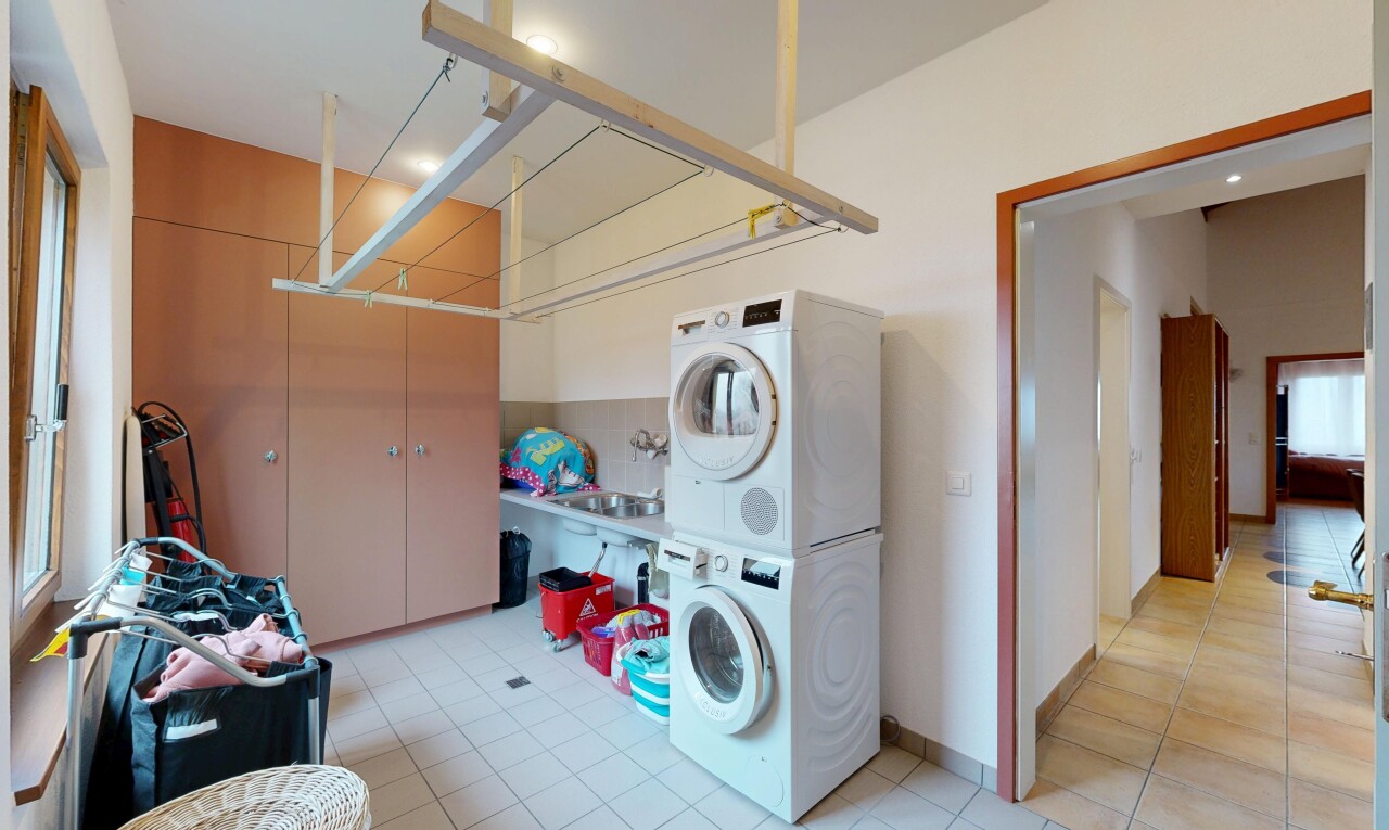 buanderie avec buanderie, cloison sèche, drywall, sol en carrelage, et tile floor