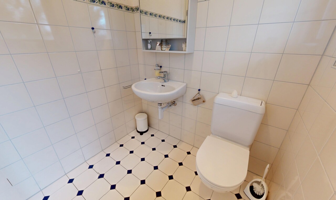 salle de bains avec toilette, miroir, mur en carrelage, tile wall, et inside property