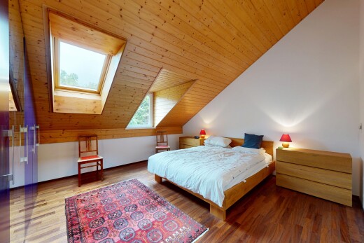 chambre avec pièce supplémentaire, plafond voûté, vaulted ceiling, inside property, et sol en finition bois
