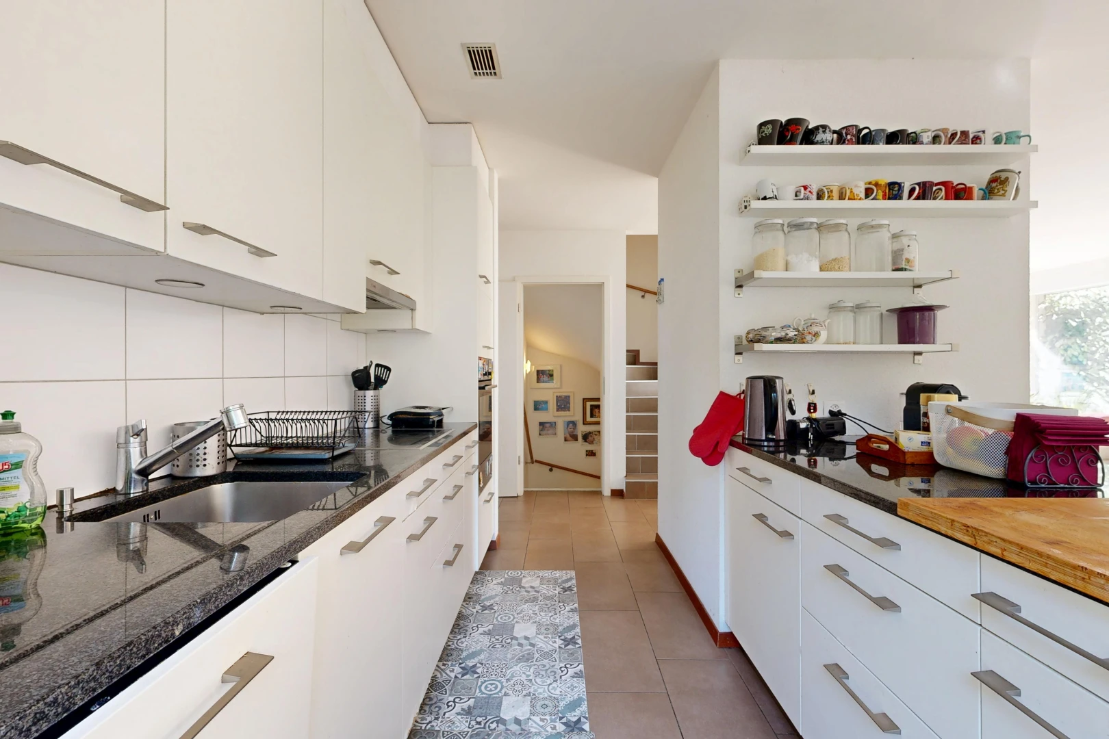 kitchen featuring white cabinets, open shelves, dark stone countertops, and light tile patterned flooring