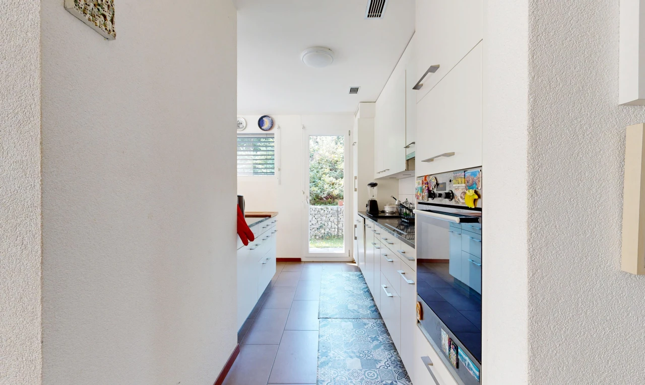 kitchen with access to outside, wall oven, dark countertops, and white cabinetry