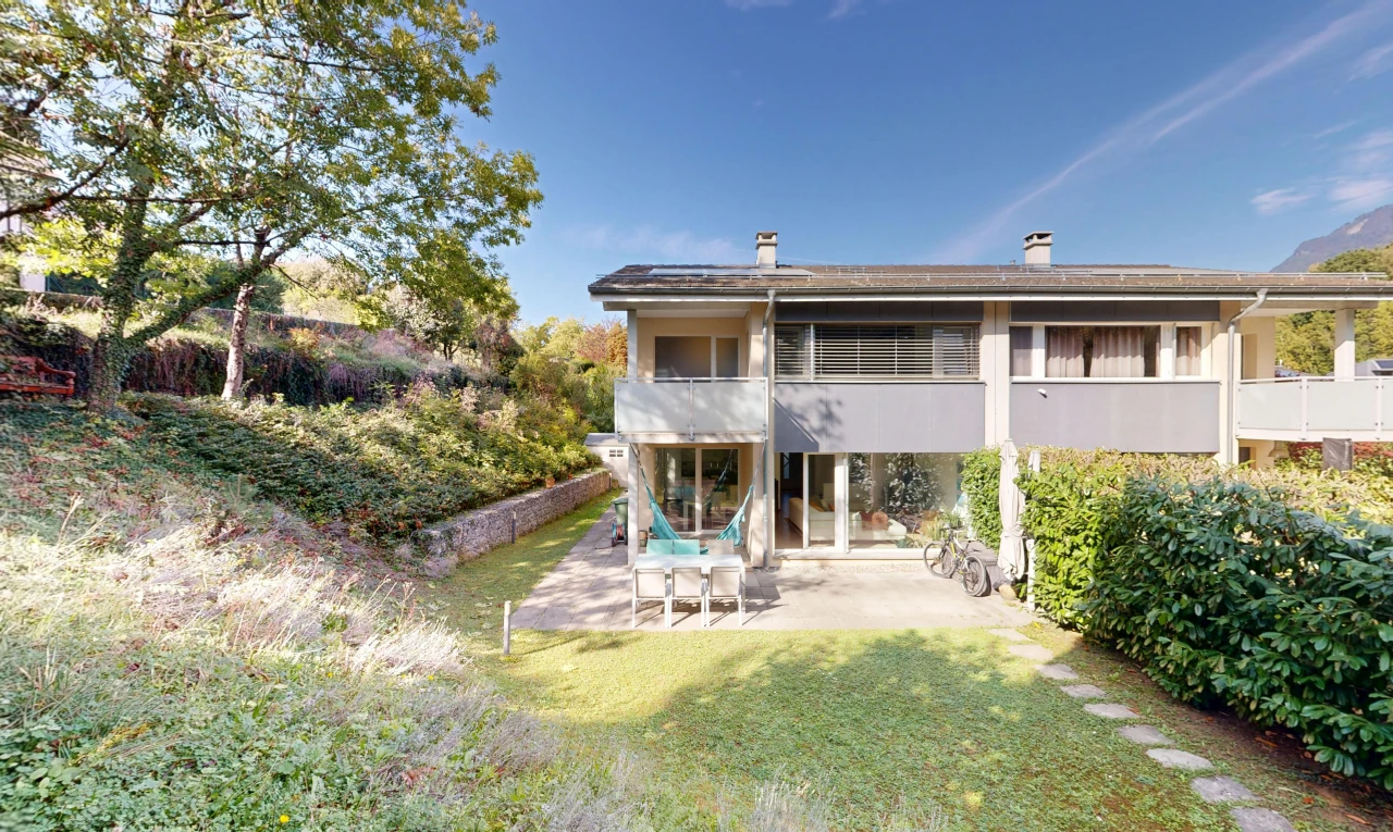 view of property featuring a balcony, a patio area, a yard, and a chimney