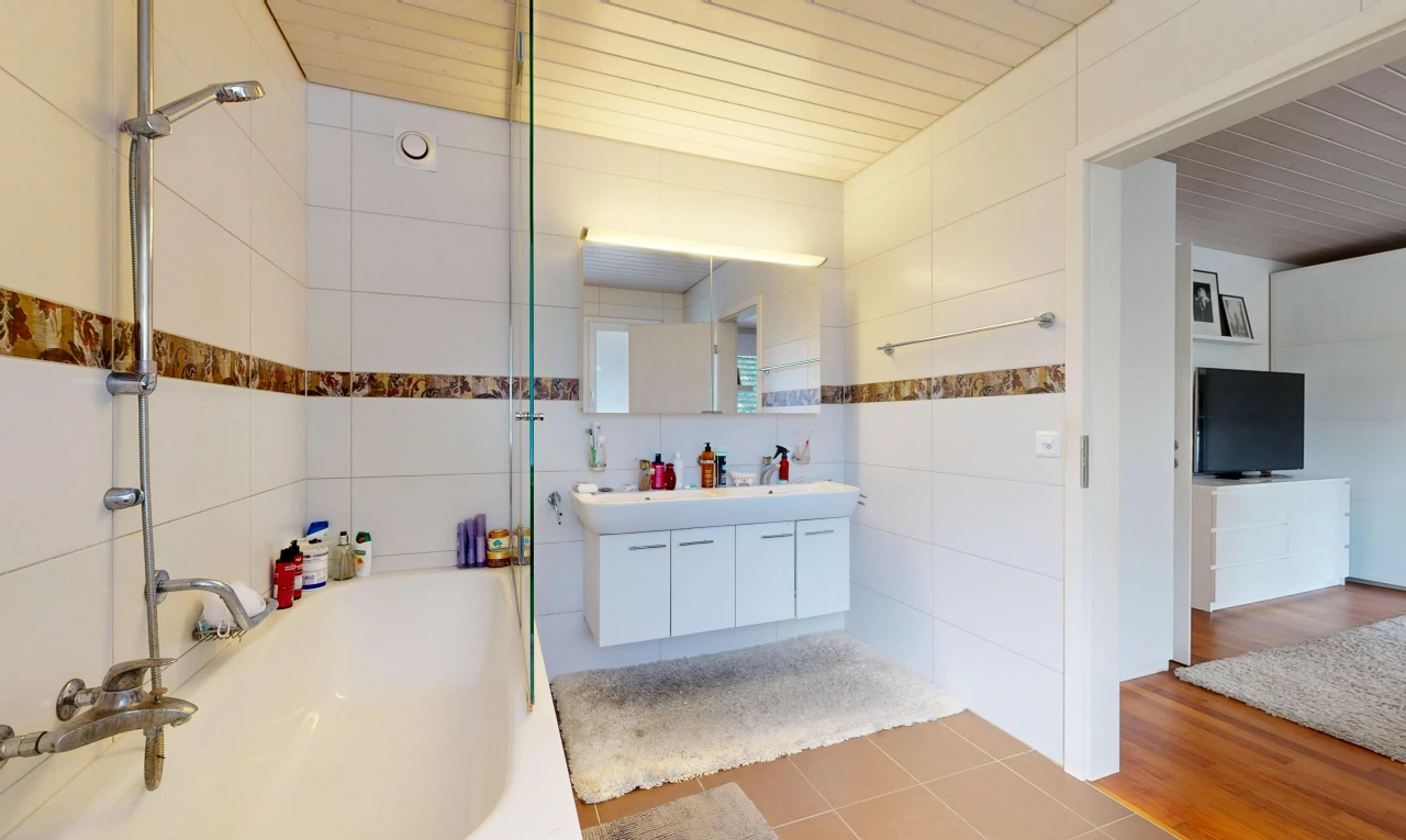 bathroom with double vanity, bathtub / shower combination, tile walls, and light tile patterned flooring
