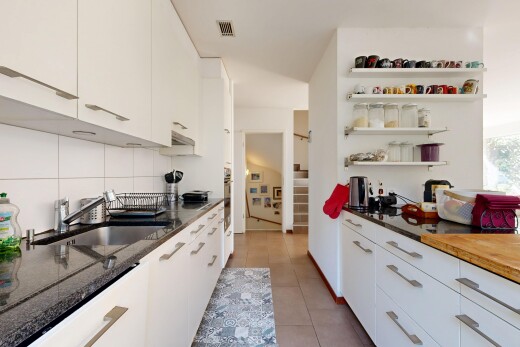 küche mit dark countertops, white cabinets, weiße schränke, treppen, und open shelves