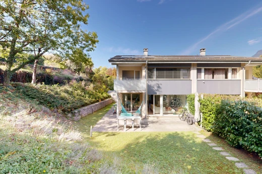 view of property featuring a balcony, a patio area, a yard, and a chimney
