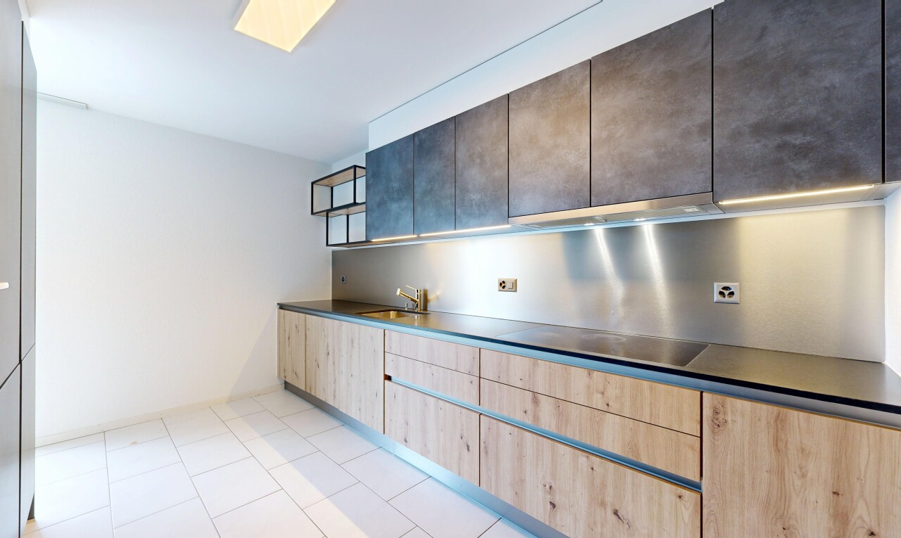 cuisine avec light floor, dark countertops, plans de travail, drywall, et cloison sèche
