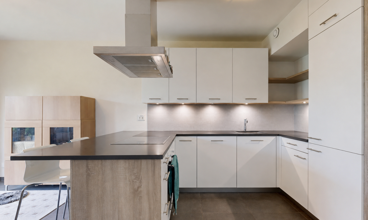 cuisine avec kitchen peninsula, péninsule de cuisine, hotte, dark countertops, et plans de travail