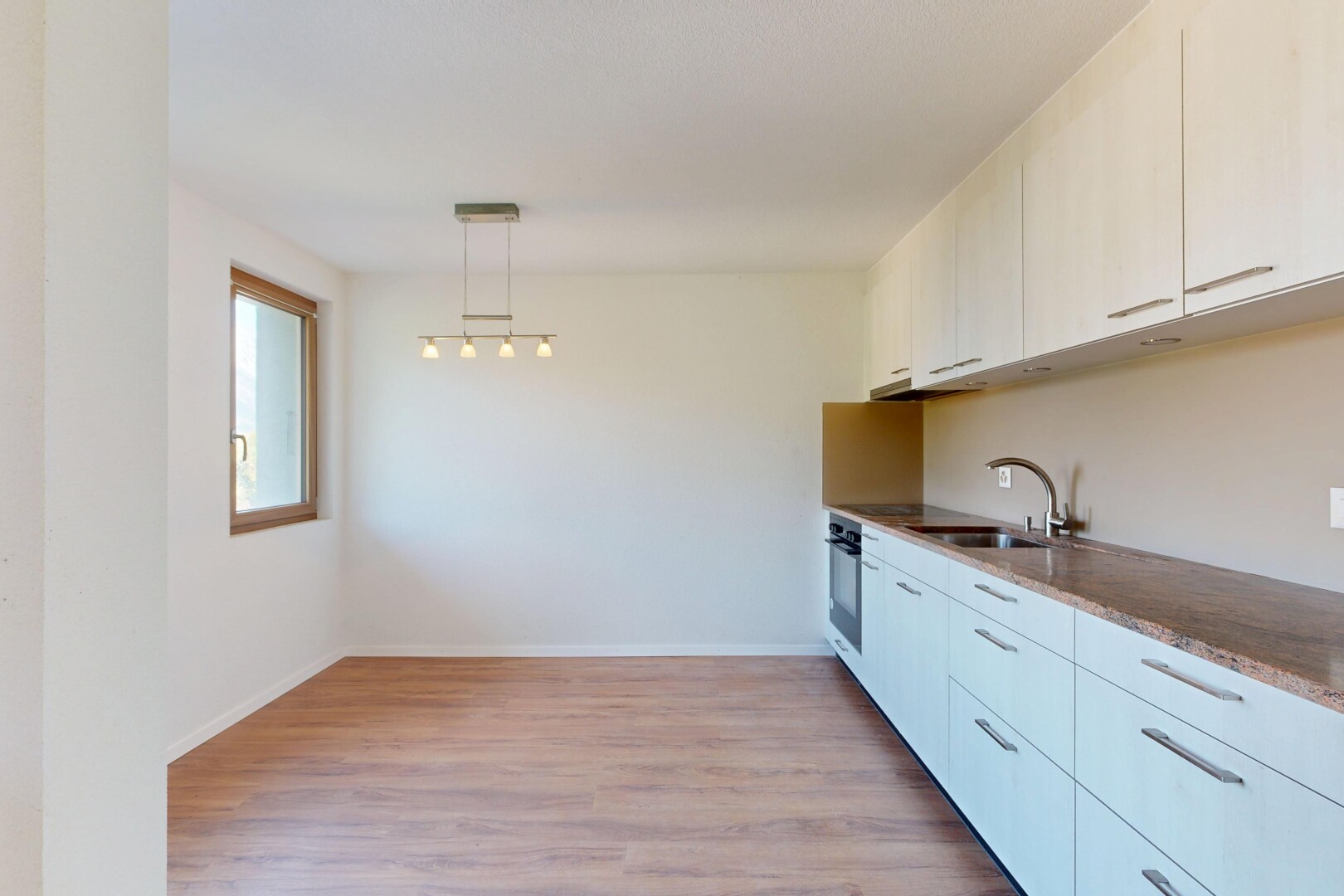 cuisine avec sol en finition bois, wood finish floor, cloison sèche, drywall, et éclairage suspendu