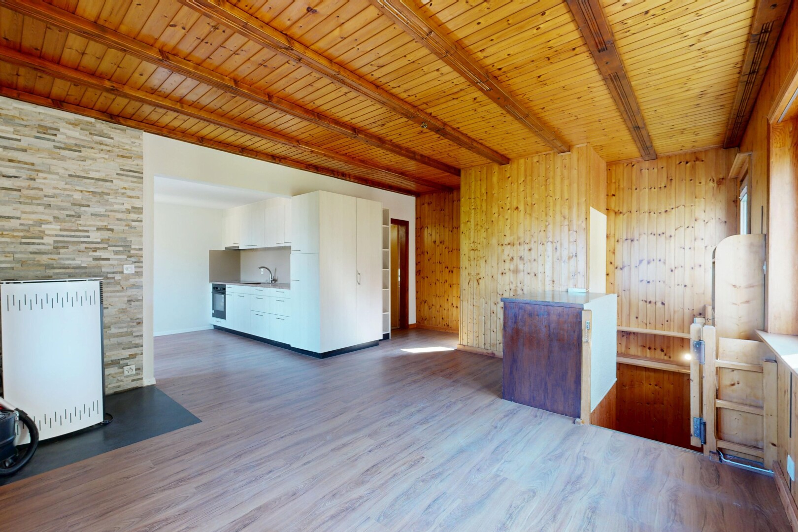 pièce vide avec plafond à poutres, beamed ceiling, sol en finition bois, wood finish floor, et plafond en bois