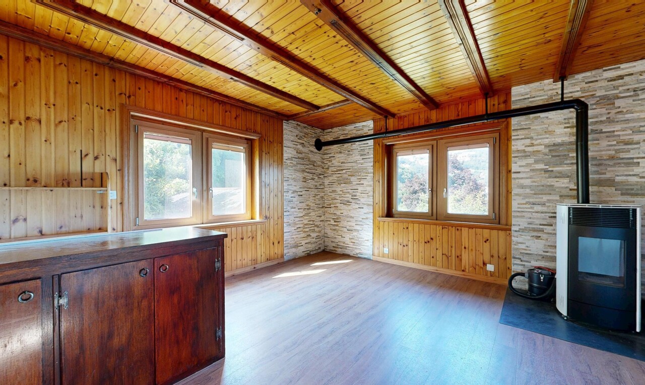 pièce vide avec poêle à bois, sol en finition bois, wood finish floor, inside property, et mur en bois