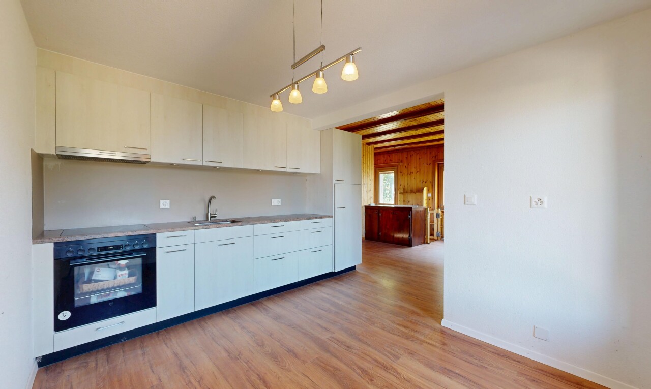 cuisine avec four, plans de travail, light countertops, inside property, et sol en finition bois