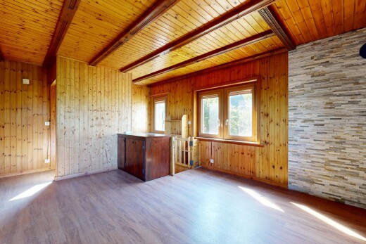 pièce vide avec plafond à poutres, beamed ceiling, lumière naturelle, natural light, et sol en finition bois