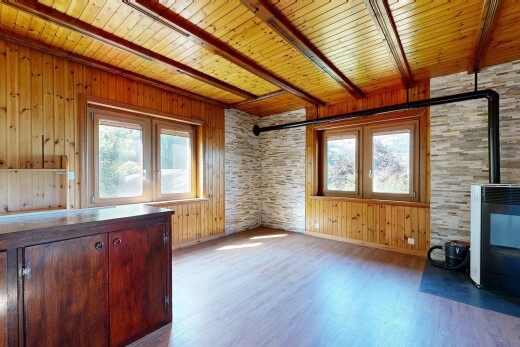 pièce vide avec poêle à bois, sol en finition bois, wood finish floor, inside property, et mur en bois