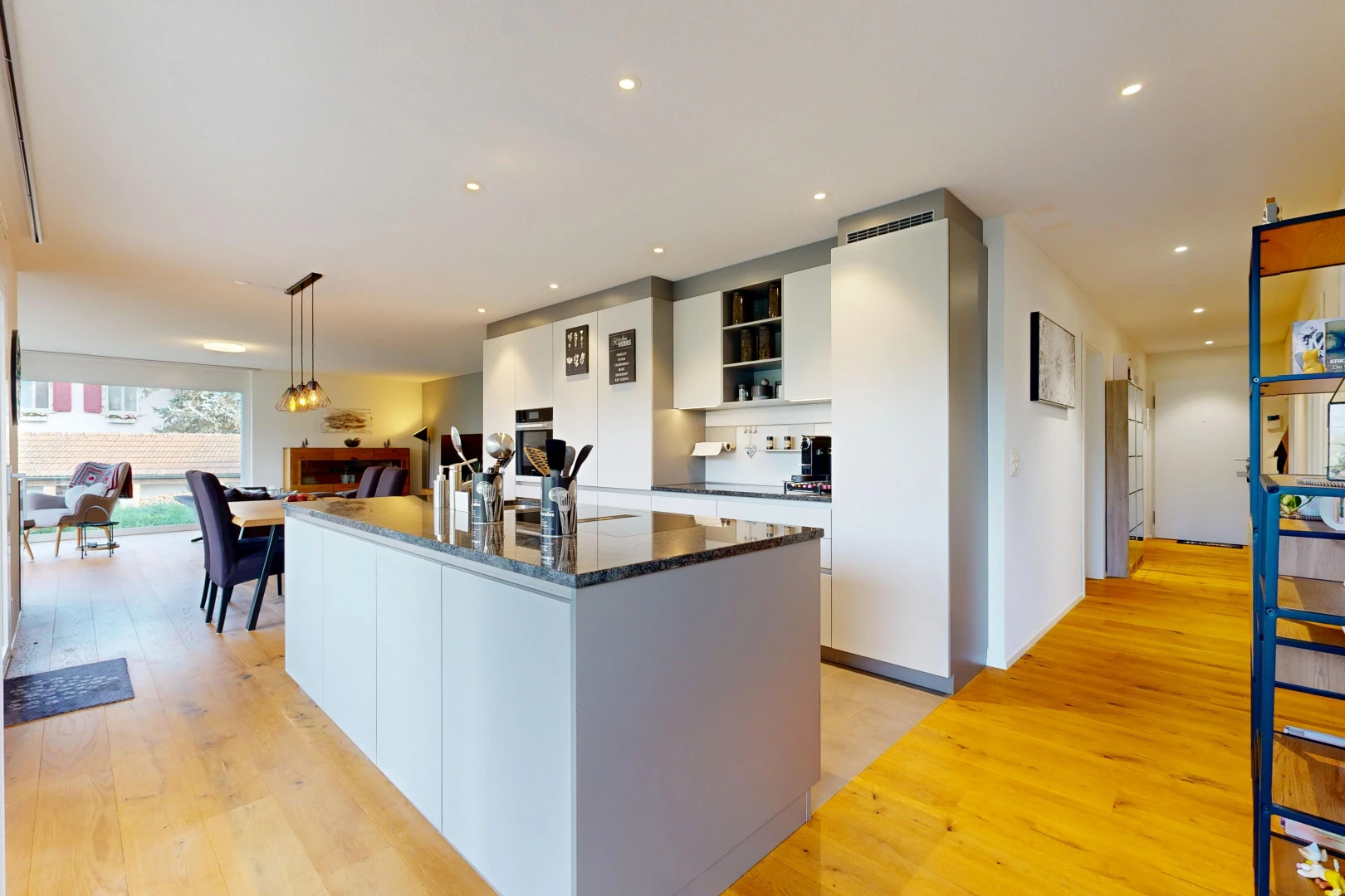 cuisine avec dark countertops, éclairage encastré, kitchen island, îlot de cuisine, et wood finish floor