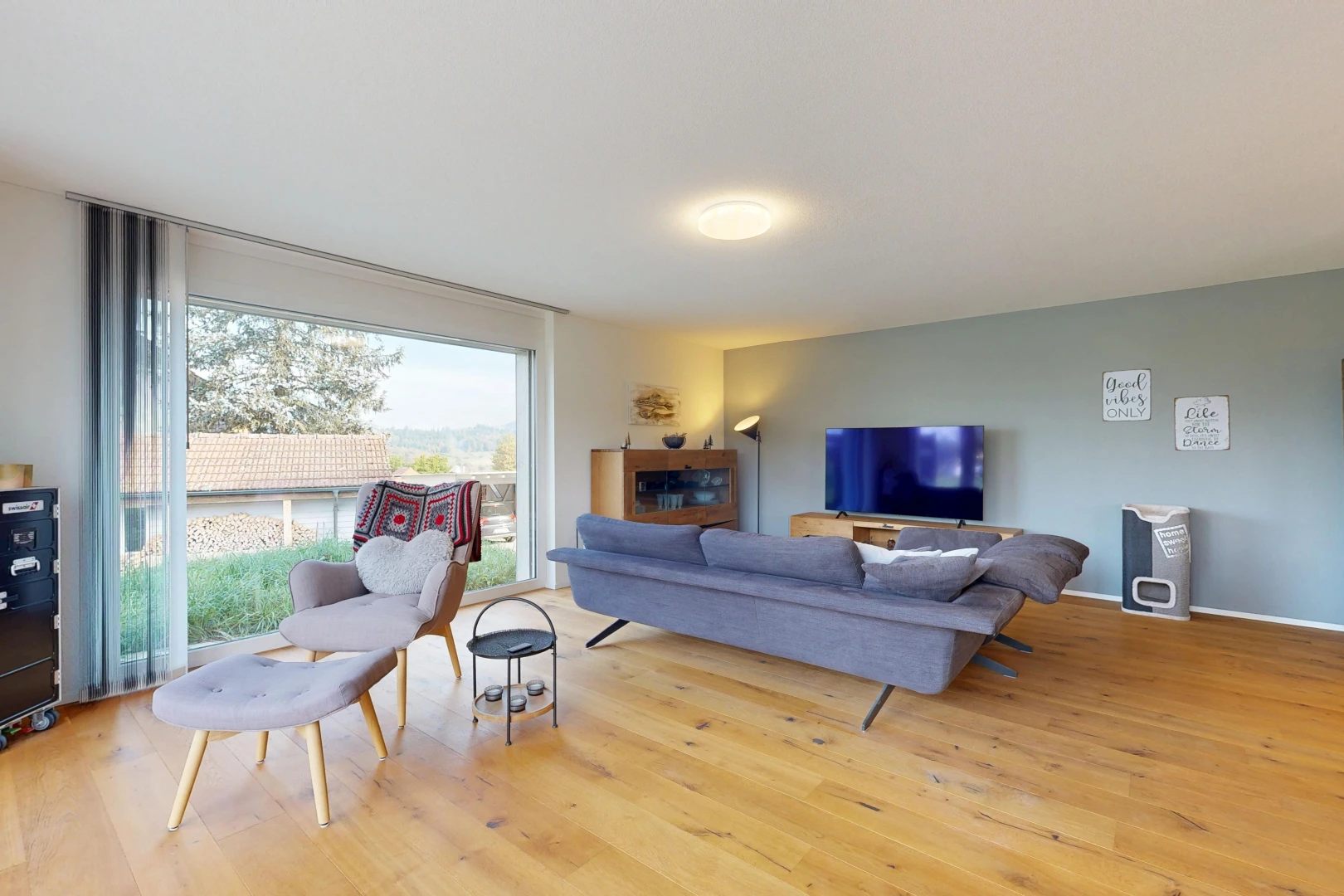 salon avec drywall, cloison sèche, télévision, wood finish floor, et sol en finition bois