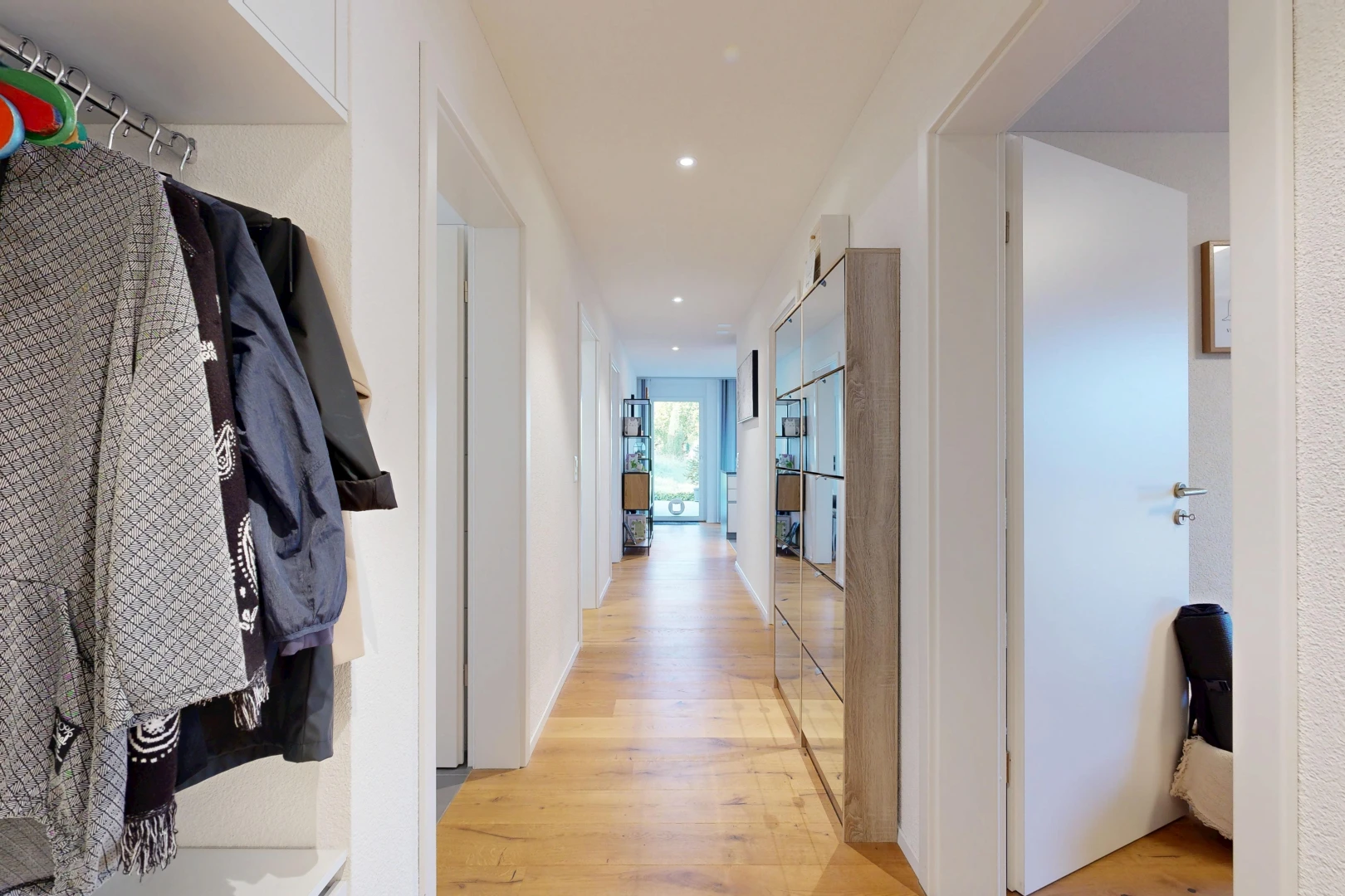 couloir avec light floor, éclairage encastré, sol en finition bois, wood finish floor, et inside property