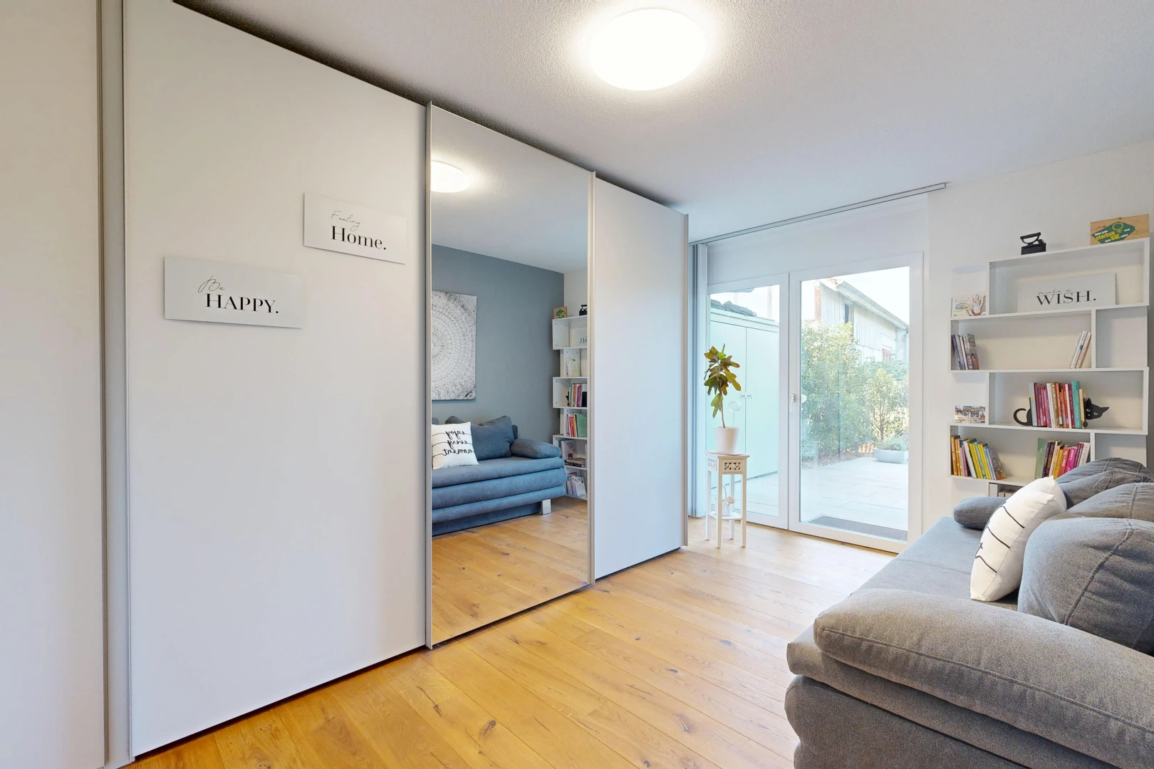 salon avec wood finish floor, sol en finition bois, accès à l'extérieur, drywall, et cloison sèche