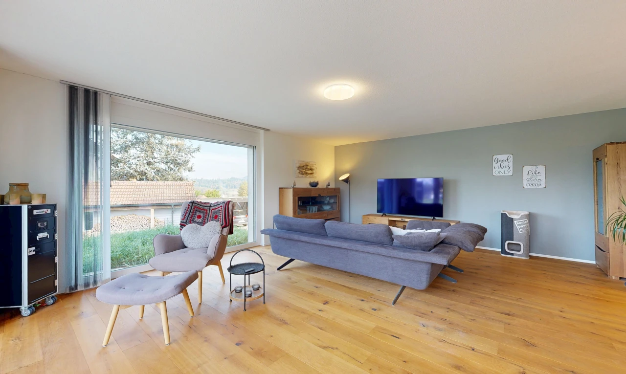 salon avec drywall, cloison sèche, télévision, wood finish floor, et sol en finition bois