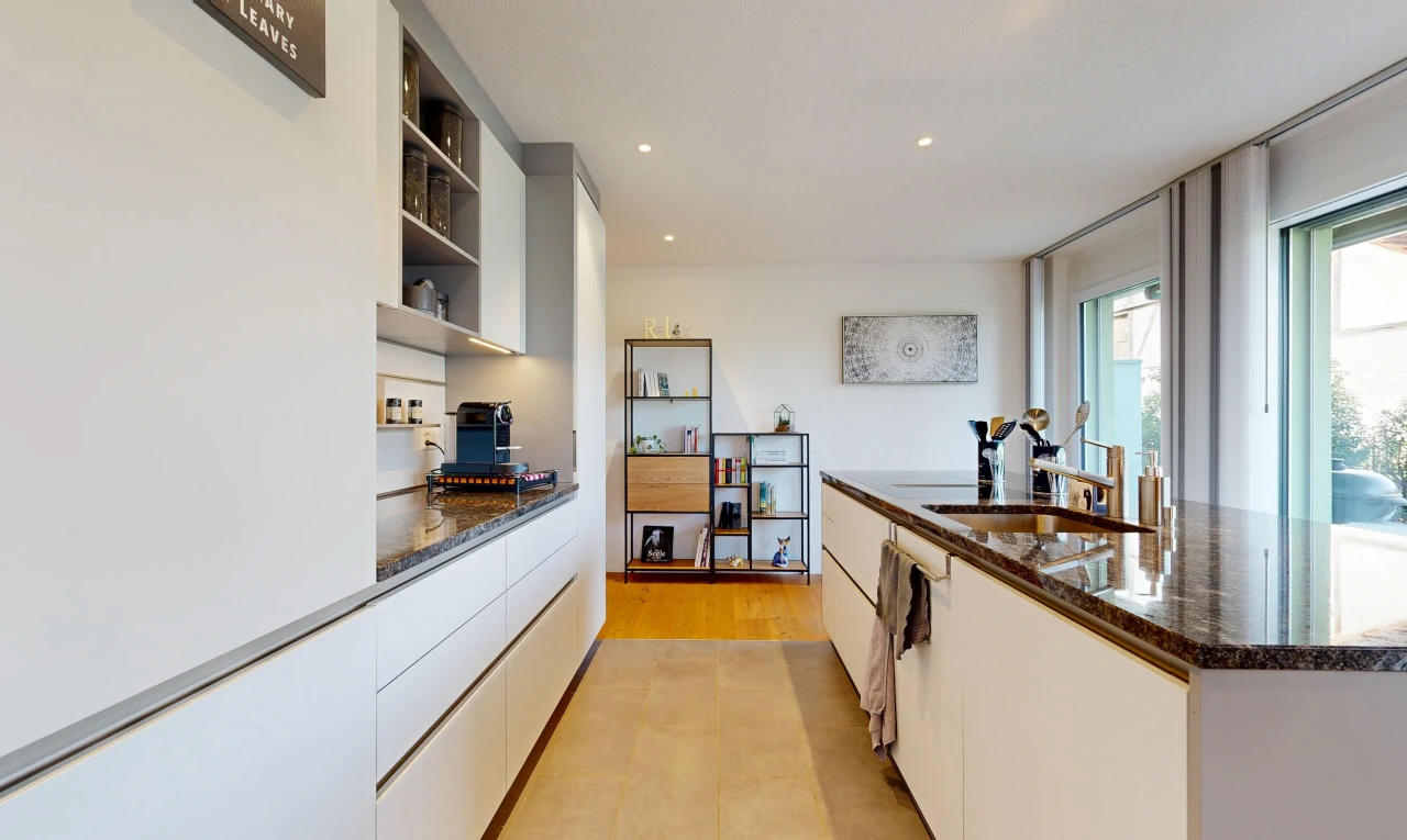 cuisine avec dark countertops, stone countertops, plans de travail en pierre, light floor, et étagères intégrées