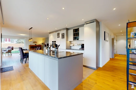 cuisine avec dark countertops, éclairage encastré, kitchen island, îlot de cuisine, et wood finish floor