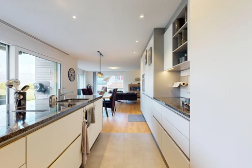 cuisine avec dark countertops, stone countertops, plans de travail en pierre, light floor, et éclairage encastré