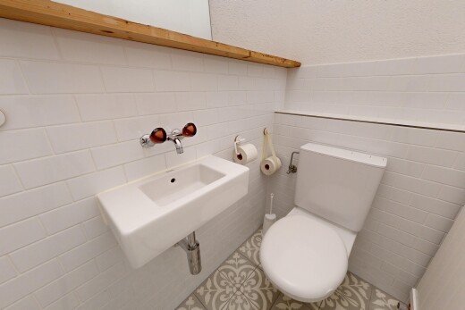 salle de bains avec toilette, évier, inside property, mur en carrelage, et tile wall