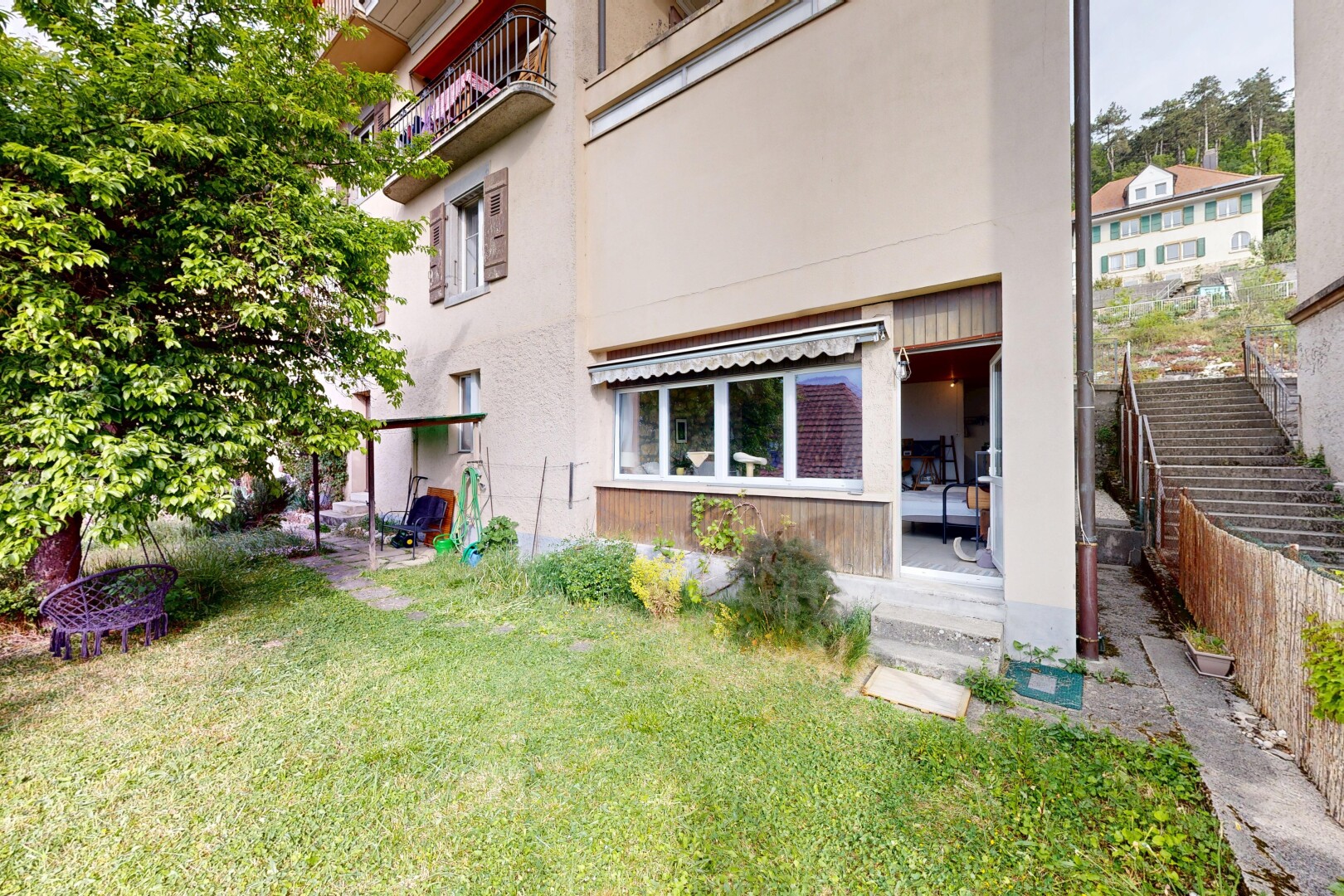 façade avec auvent, bardage en stuc, pelouse, et terrasse